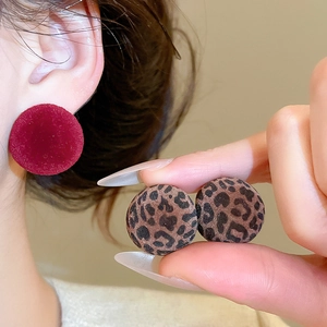 Detailed view of red flocking and leopard print button earrings with soft fiber texture