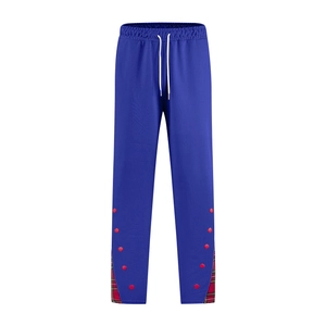 Détail du jogging bleu avec boutons rouges et patchwork écossais sur l'ourlet