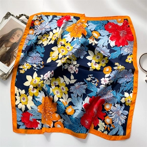 Close-up of floral patterns on dark blue silk scarf with decorative orange borders