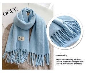 Close-up of the light blue cashmere-like scarf showing soft texture and tassel details