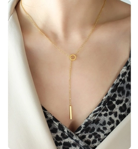 Detail of 18K gold-plated Y-shaped necklace with ring and vertical bar tassel on model