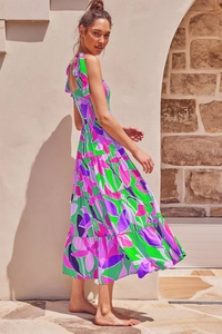Detail of vibrant tropical floral print tiered maxi dress with smocked bodice and ties
