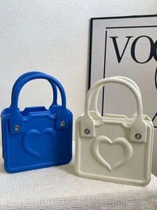 Detail of EVA beach tote bags featuring embossed heart patterns in royal blue and beige