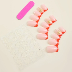 French tip press-on nails set with red accents, gold bows, nail file, and adhesive tabs