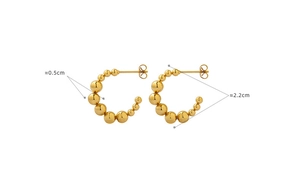 Détail de boucles d'oreilles créoles dorées à billes, diamètre 2,2 cm et finition polie