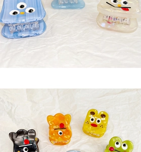 Close-up of colorful acetate mini hair claws with cute cartoon monster faces and 3D eyes