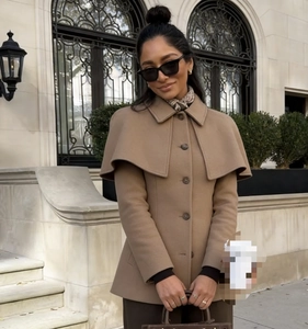 Detail of camel wool blend cape coat with single-breasted buttons and layered collar