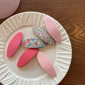 Set of 6 sweet floral fabric BB hair clips for kids on a white ceramic plate