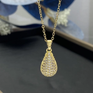 Close-up of a gold-plated teardrop pendant necklace encrusted with white zircon stones