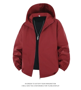 Detail view of red hooded jacket featuring zipper closure and elastic cuffs with black tee