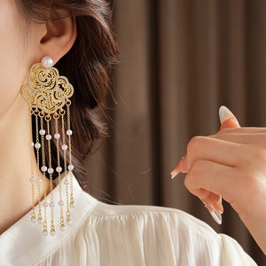 Detail of flower tassel earrings with golden clouds, sparkling diamonds and pearls