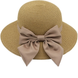 Dettaglio cappello di paglia con un grande ed elegante fiocco di raso marrone