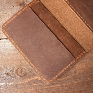 Detailed close-up of stitching and internal card slots on a vintage brown leather wallet