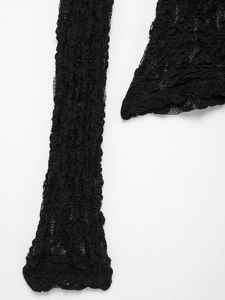 Close-up of intricate black lace texture and hollow out patterns on slim fit knit top
