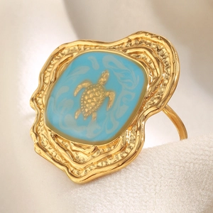 Macro shot of 18K gold plated turtle ring with blue enamel and hammered metal textures