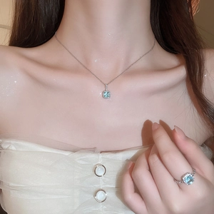 Exquisite halo jewelry set with light blue square stones worn by a model in warm light