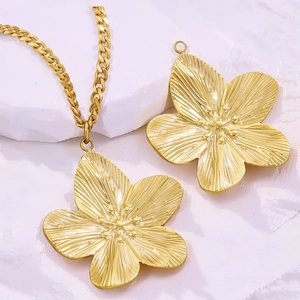 Detailed view of vintage gold flower pendant with fine textures on a textured surface