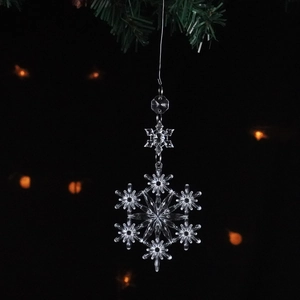 Clear acrylic snowflake crystal ornament with festive Christmas background lighting