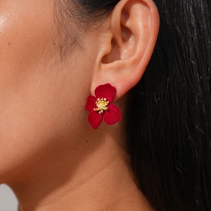Boucles d'oreilles fleurs floquées rouges vintage avec détails dorés portées