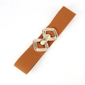 Détail d'une large ceinture élastique marron caramel avec boucle géométrique dorée