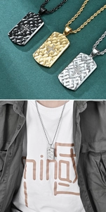Detail of dog tag pendants in black, gold, and silver with cross inlay and chain