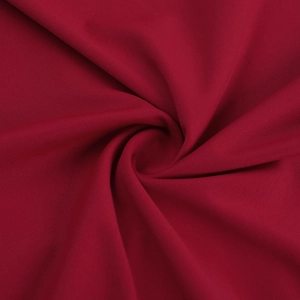 Detail shot of deep red knitted fabric showing high density texture and soft drape