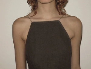 Detailed view of dark brown spider web dress showing thin straps and coarse linen texture
