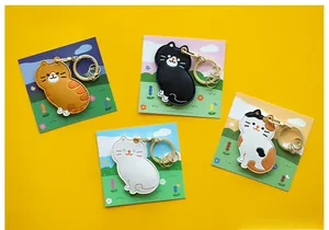 Détail de quatre mignons porte-clés chat en simili cuir aux motifs variés et anneaux dorés