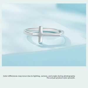 Detailed macro view of S925 sterling silver minimalist cross ring on blue display stand