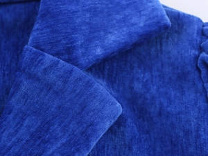 Dettaglio del rever in velluto blu reale che mostra la morbida consistenza del tessuto