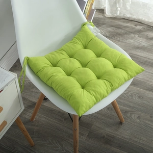 Detail of bright green tufted chair cushion with secure ties on a white chair