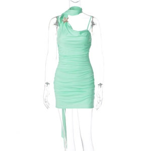 Detail of mint green ruched bodycon dress featuring star brooch and neck tie accents