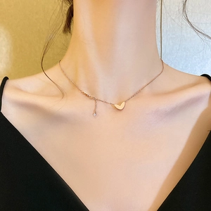 Collana minimalista con ciondolo a cuore in oro rosa e acciaio titanio su modella