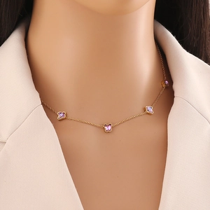 Elegante collana girocollo d'oro con cinque piccoli farfalle viola su una modella donna