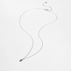 Macro view of sterling silver pear-shaped pendant necklace with a delicate star pattern