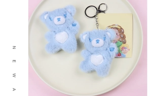 Close-up of two blue plush bears with heart embroidery on a decorative tray