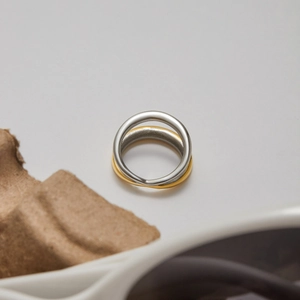 Macro shot of two-tone intertwined gold and silver stainless steel ring with mirror polish