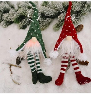 Detail of Christmas gnomes with knit hats and long striped legs on snowy background