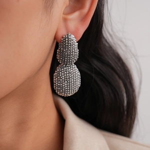 Vue détaillée de boucles d'oreilles ovales en forme de larme avec cristaux sur le modèle