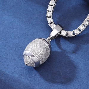 Macro view of silver football pendant necklace with sparkling tennis chain on blue surface