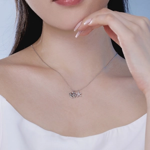Close-up of S925 silver necklace with shell and starfish charms on a female model