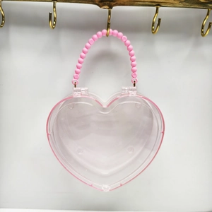 Detail van hartvormige transparante opbergcase met roze kralen handvat op houten standaard