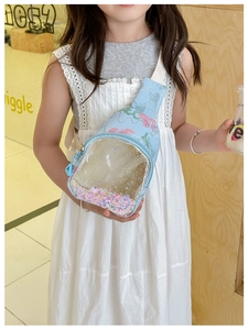 Close-up of light blue kids crossbody bag with floral pattern and glitter sand detail