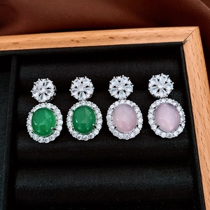 Macro detail of emerald and pink chalcedony earrings with zircon floral studs