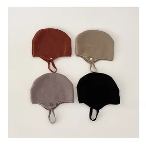 Detail of baby knitted earflap hats in four colors with secure chin straps and buttons