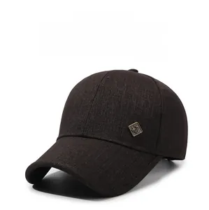 Détail d'une casquette de baseball marron café avec badge métallique vintage et sergé