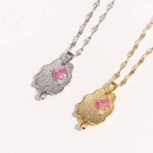 Detail of gold and silver necklaces with irregular texture pendants and pink zircon