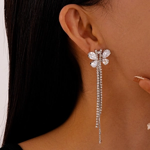 Close-up of model wearing silver butterfly tassel earrings with sparkling zircon crystals