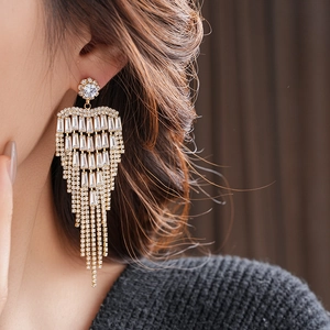 Macro shot of long layered tassel earrings with gold base and sparkling zircon stones