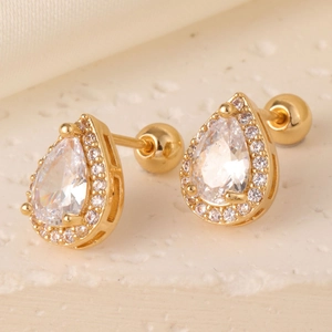 Macro detail of gold teardrop earrings with pear-cut zircon and secure screw-back closure
